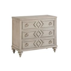 an antique white dresser with three drawers