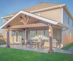 a covered patio with table and chairs in front of a house on a sunny day