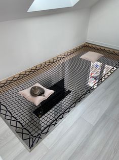 a cat laying on top of a bed in a room with white walls and wooden floors