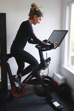 a woman on a stationary bike using a laptop