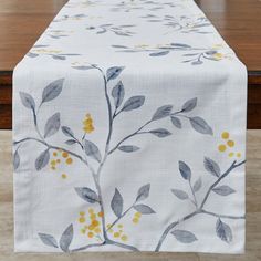 a table runner with yellow and grey leaves on it