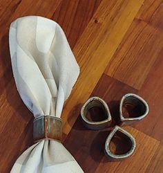 two napkins and some silver scissors on a wooden floor