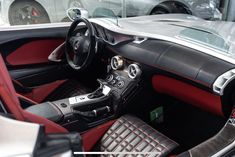 the interior of a sports car with red and black leather