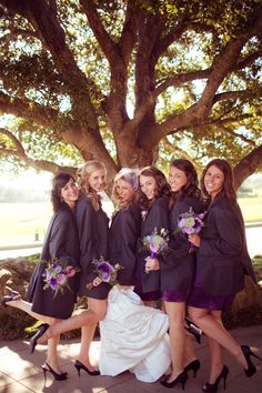 a group of women standing next to each other near a tree