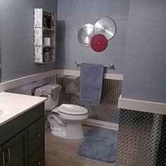 a white toilet sitting in a bathroom next to a sink under a mirror on a wall