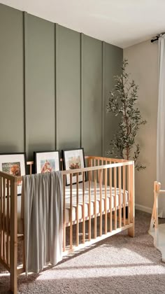 a baby's crib in the corner of a room with pictures on it