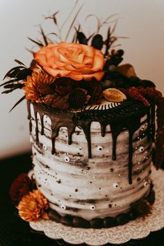 a decorated cake sitting on top of a table next to a white plate with orange flowers