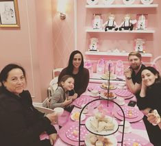 a group of people sitting around a pink table