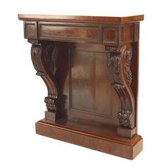 an ornate wooden shelf with carvings on the top and bottom, against a white background