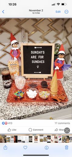 two elfs are standing behind a sign that says sunday's are for sundaes