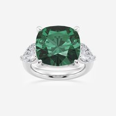 a cushion cut green diamond ring with three diamonds on the band and an oval shaped center stone