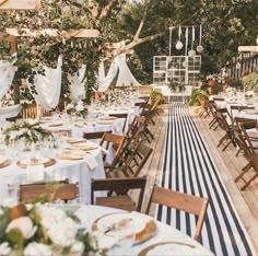 an outdoor dining area with tables and chairs set up for a formal function in the sun