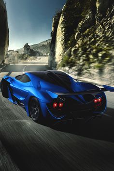 a blue sports car driving down the road