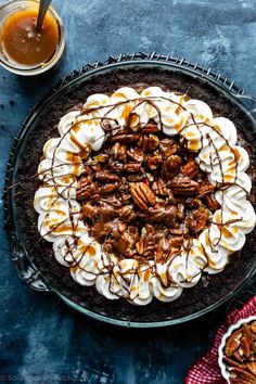 a pie with pecans, whipped cream and caramel drizzle on top