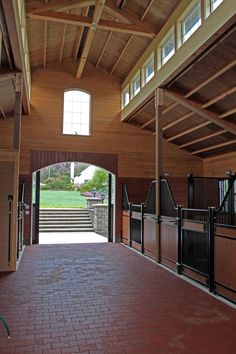 the inside of a horse barn with doors open