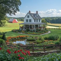 a large white house sitting in the middle of a lush green field next to a pond