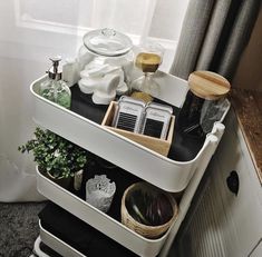 a white shelf filled with lots of items next to a window