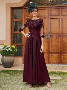 a woman standing in front of a door wearing a dress with sheer sleeves and beading