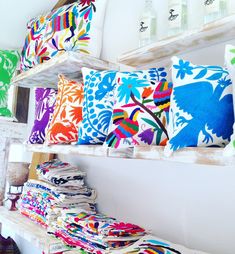 brightly colored pillows are lined up on shelves