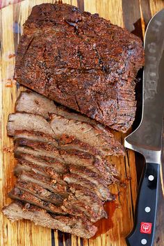 sliced meat sitting on top of a cutting board next to a knife