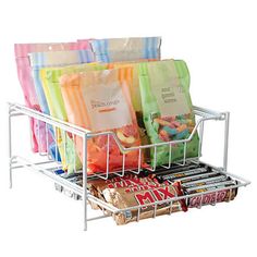 several bags of candy are stacked in a wire basket on top of each other,