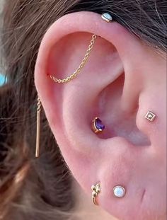 a woman wearing three different piercings on her ear