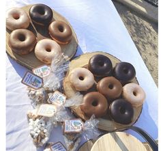 there are many donuts on the table with other pastries and snacks around it