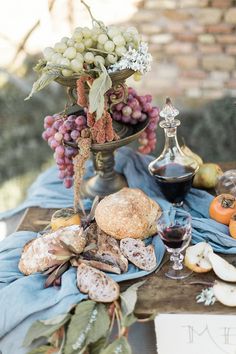 a table with bread, grapes and other food on it