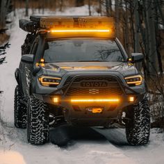 the front end of a gray truck with yellow lights on it's headlamps