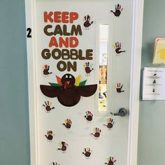 a door decorated with handprints and the words keep calm and gobble on