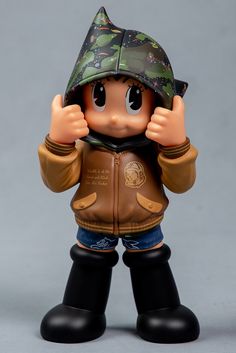 a figurine wearing a jacket and hat with one hand up to his face