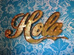 an illuminated sign with the word golla on it's side, in gold and blue