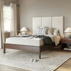 a bedroom with a bed, nightstands and two lamps on either side of the bed