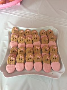 a plate full of cookies with pink frosting on them and teddy bears in the middle