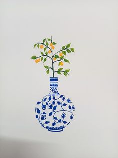 a blue and white vase with oranges in it is hanging from the ceiling above