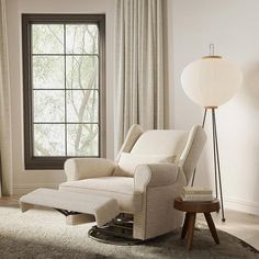 a living room with a chair, ottoman and lamp in front of a large window