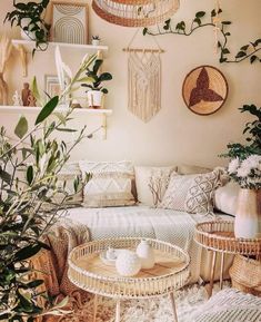 a living room with wicker furniture, plants and pictures on the wall above it