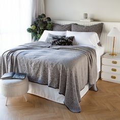 a bedroom with a bed, two nightstands and a window