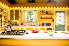 a kitchen with yellow cabinets and white counter tops is seen in this image from the front view