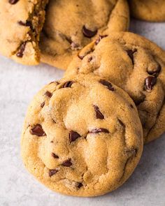 several chocolate chip cookies on a white surface