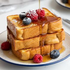 a stack of french toast topped with syrup and berries