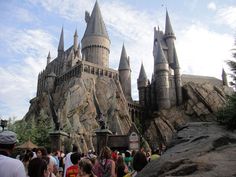 people are standing in front of hogwarts castle at the wizard's village