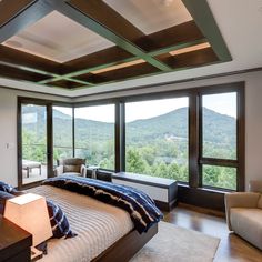 a bedroom with large windows overlooking the mountains