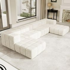 a large white couch sitting in front of a window on top of a carpeted floor