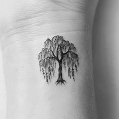 a small tree tattoo on the side of a woman's right arm and neck