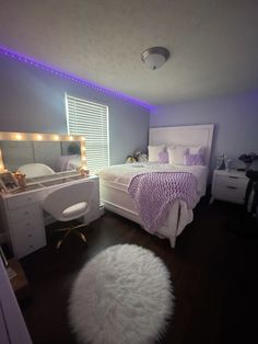 a bed room with a neatly made bed and purple lighting