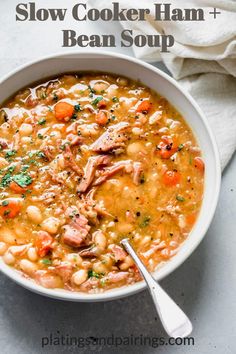 a white bowl filled with chicken and bean soup on top of a table next to a napkin