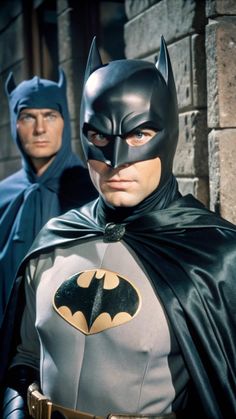 two men in batman costumes standing next to each other