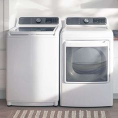 two washers and a dryer sitting next to each other in a laundry room