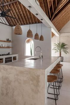 a large kitchen with an island counter top and stools next to it, surrounded by open shelves